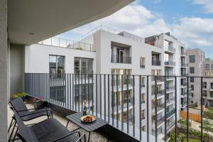 een balkon met 2 stoelen en een wit gebouw bij Stylish Flat by the Metro in Praag