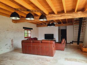 a living room with a couch and a television at Gîte Côté Val in Montlivault