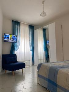 a bedroom with a bed and a blue chair at La casetta di Andreina in Sarzana