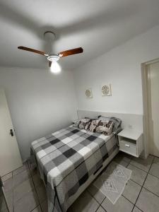 a bedroom with a bed and a ceiling fan at AP 100m do mar mesma rua do Quiosque VavaZão in Capão da Canoa