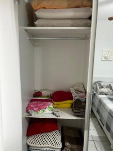a closet filled with lots of towels and blankets at AP 100m do mar mesma rua do Quiosque VavaZão in Capão da Canoa