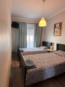 a bedroom with two beds and a light at Bibel Ocean Home Sunset by the sea in Vila Praia de Âncora +30 photos