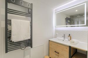 ein Badezimmer mit Waschbecken und Spiegel in der Unterkunft Le Siméon - T2 plein pied, cosy, au cœur de la zone piétonne in Vienne