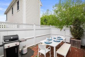 Un patio con mesa y sillas y parrilla. en Stylish Walk to Town and Beach, en Provincetown
