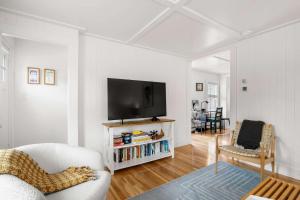 Una sala de estar con un televisor en una pared blanca. en Stylish Walk to Town and Beach, en Provincetown