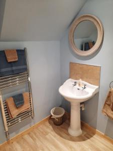 a bathroom with a sink and a mirror at A Stylish Country Retreat! in Keilour
