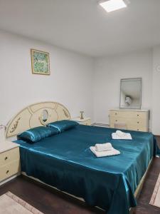 a bedroom with a blue bed with two towels on it at Studio D&I in Vranje