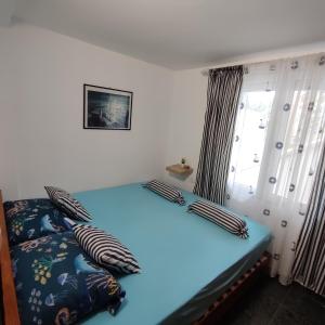 a bedroom with a bed with pillows and a window at Holiday home Sutomore in Sutomore