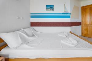 a white bed in a room with a striped wall at Villa Katharina in Utjeha
