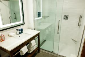 a bathroom with a glass shower and a sink at Four Points by Sheraton Austin Airport in Austin +53 photos