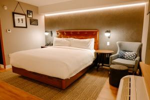 オースティンにあるFour Points by Sheraton Austin Airportのベッドと椅子のあるホテルの部屋