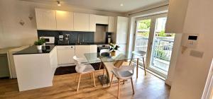a kitchen with a glass table and white chairs at John Double Room in London