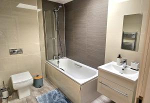 a bathroom with a tub and a sink and a toilet at John Double Room in London +14 photos