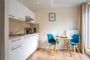 a small kitchen with blue chairs and a table at Home Zwo Apartments Bad Salzhausen Tiny 4 in Nidda