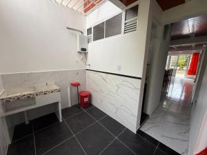 uma cozinha com paredes de mármore branco e uma lata de lixo vermelha em Apartamento Piso 1 Casa 6 Hotel Atlantis em Líbano mais 1 fotografia