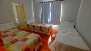 a room with two beds and a window at Pousada Estação do Pedrão in Maria da Fé