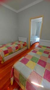 a room with two beds and a door to a bedroom at Pousada Estação do Pedrão in Maria da Fé