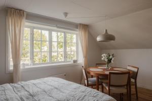 a bedroom with a table and a bed and a window at Äleklinta in Äleklinta