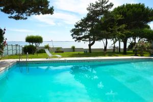 - une piscine avec une chaise et des arbres dans l'établissement Villa avec piscine chauffée et magnifique vue mer, à Royan