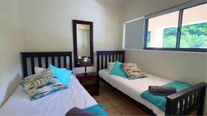 a bedroom with two beds and a window at Santos View 40 in Mossel Bay