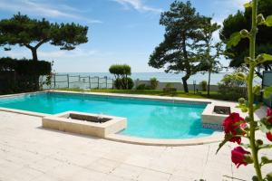 une piscine avec l'océan en arrière-plan dans l'établissement Villa avec piscine chauffée et magnifique vue mer, à Royan