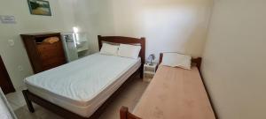 a small bedroom with a bed and a dresser at Encantadora Chácara com Piscina em Itanhaém in Itanhaém +57 photos