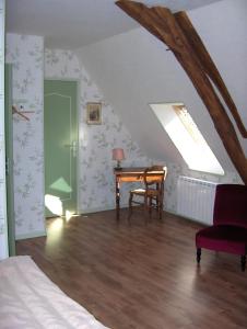 MorlacChambre d'hôte La Berthoderie的一间卧室配有书桌、床和窗户。