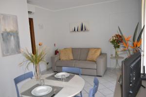 a living room with a table and a couch at Appartamento Camineve 1 in Loano
