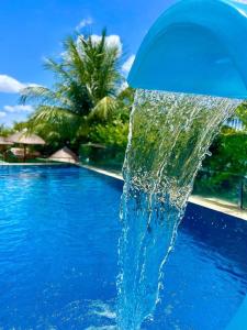 a water fountain in the middle of a swimming pool at Aconchego Matuto - Hotel Club e Restaurante in Canindé de São Francisco