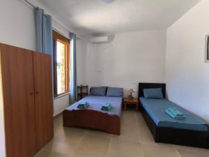 a room with two beds and a table in it at KAFUL APARTMENTS in Qeparo