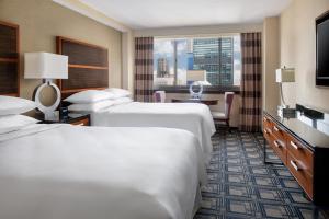 Postel nebo postele na pokoji v ubytování Sheraton New York Times Square Hotel
