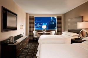 Postel nebo postele na pokoji v ubytování Sheraton New York Times Square Hotel
