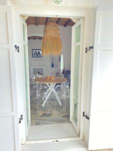 a dining room with a table and a chandelier at Villa Ruffi Mykonos in Mikonos