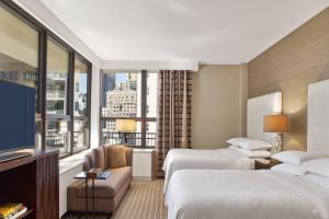 Postel nebo postele na pokoji v ubytování Sheraton New York Times Square Hotel