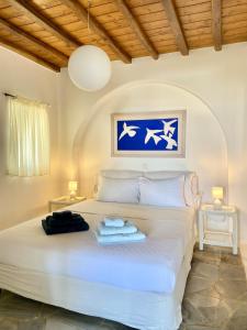 a bedroom with a white bed with two lamps at Villa Ruffi Mykonos in Mikonos +40 photos