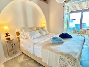 a bedroom with a large bed with towels on it at Villa Ruffi Mykonos in Mikonos