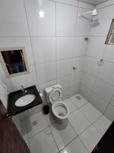 a white bathroom with a toilet and a sink at Apartamento Premium Grand Luxo in Fortaleza +3 photos