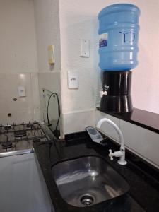 a kitchen sink with a blue bucket on top of it at Apartamento Premium Grand Luxo in Fortaleza