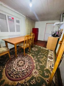 a room with a table and chairs and a rug at Kurjun in Karakol