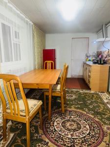 a dining room with a wooden table and chairs at Kurjun in Karakol