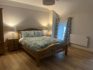 a bedroom with a bed and two lamps and a window at Self catering apartment Silvermines in Nenagh
