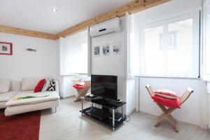 een woonkamer met een bank en een tv bij Lisbon City Center Baixa in Lissabon
