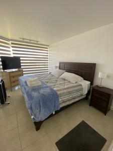 um quarto com uma cama e uma TV de tela plana em San Alfonso del Mar em Algarrobo