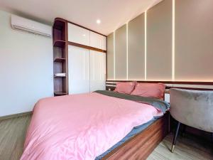ein kleines Schlafzimmer mit einem rosa Bett und einem Stuhl in der Unterkunft Hoci Homestay Vinhomes Ocean Park in Gia Lâm Pho