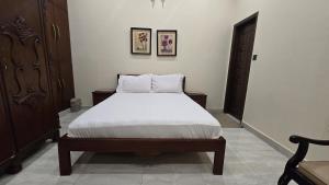 Un dormitorio con una cama grande con sábanas blancas. en Two bedroom furnished apartment in Main Shahrah e Faisal Karachi, en Karachi