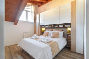 a bedroom with a large white bed and a window at La Divina Mansarda di Milano in Vittuone