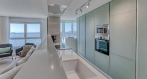 a living room with a kitchen with a stove top oven at Playa Petís in Bueu