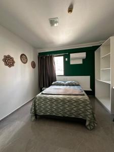 une chambre avec un lit et un mur végétal dans l'établissement Lindo Flat Boa Viagem 50m do Mar, à Récife