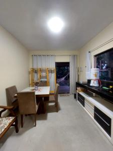 a dining room with a table and chairs and a window at Paraíso nas férias in Porto Seguro