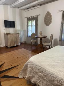ein Schlafzimmer mit einem Bett, einem Tisch und Stühlen in der Unterkunft BednBarchessa in Portogruaro